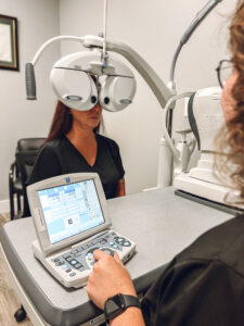 Technician using Marco's automated phoropter to refract a patient during an eye examination