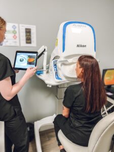 An eye care technician using Optomap technology to capture retinal images of a patient during an eye examination