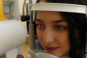 Woman in slit lamp getting eye exam